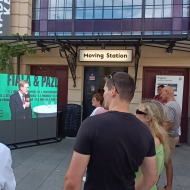 Videoprojekce před nádražím ze sálu, kde se konalo setkání s občany koalice SPOLU